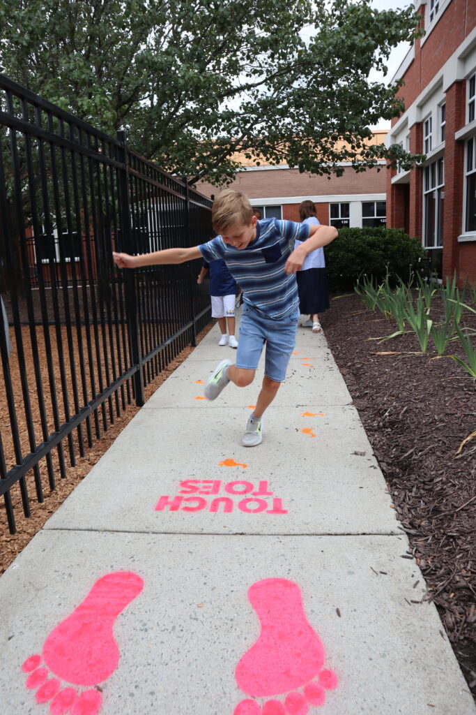 A student jumps along the sensory walk.