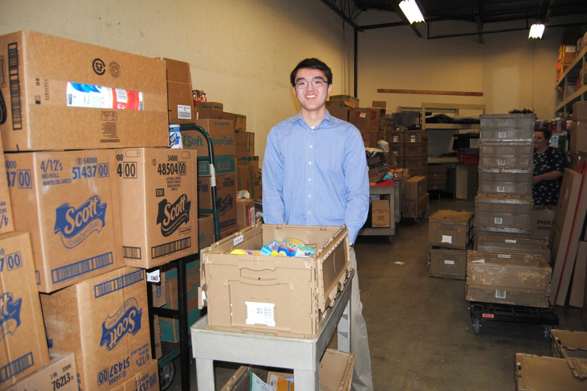 Man in back room of grocery story pushing cart of supplies