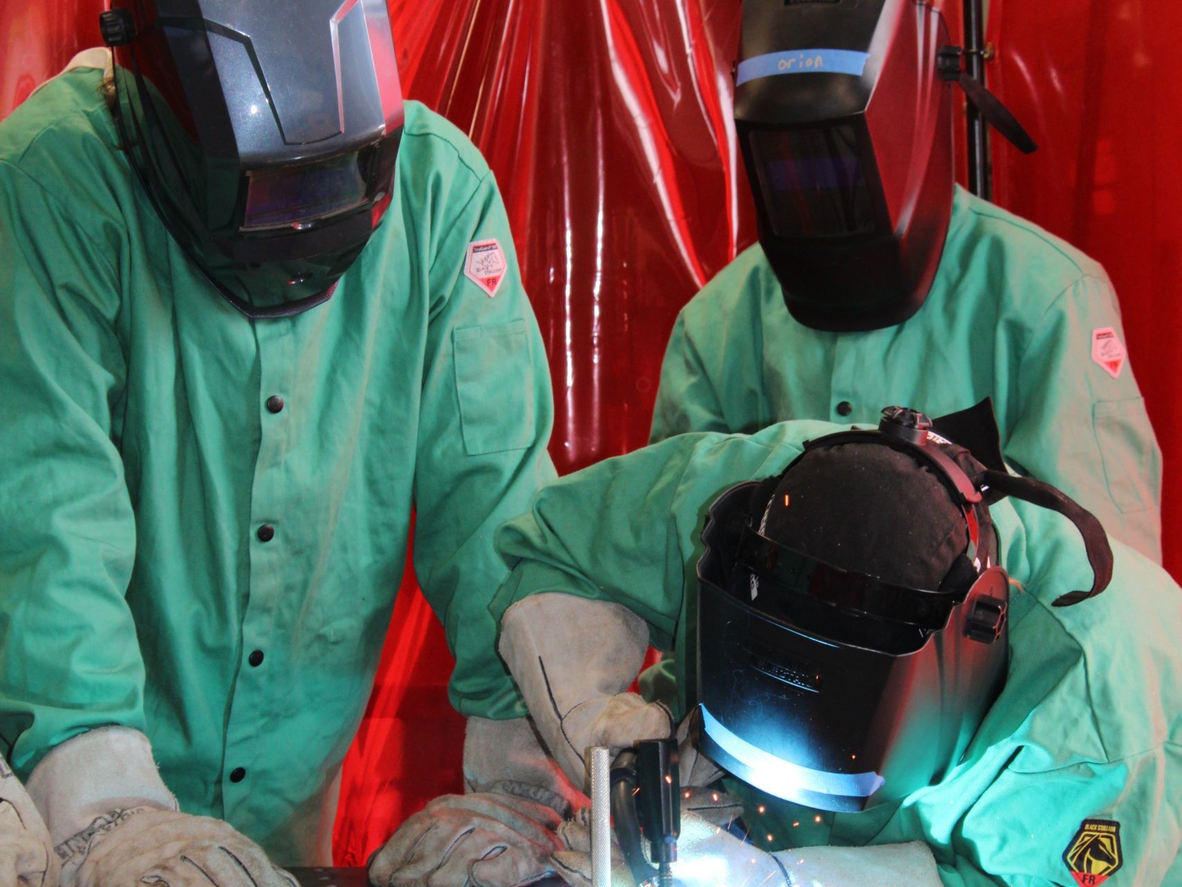 Three people welding