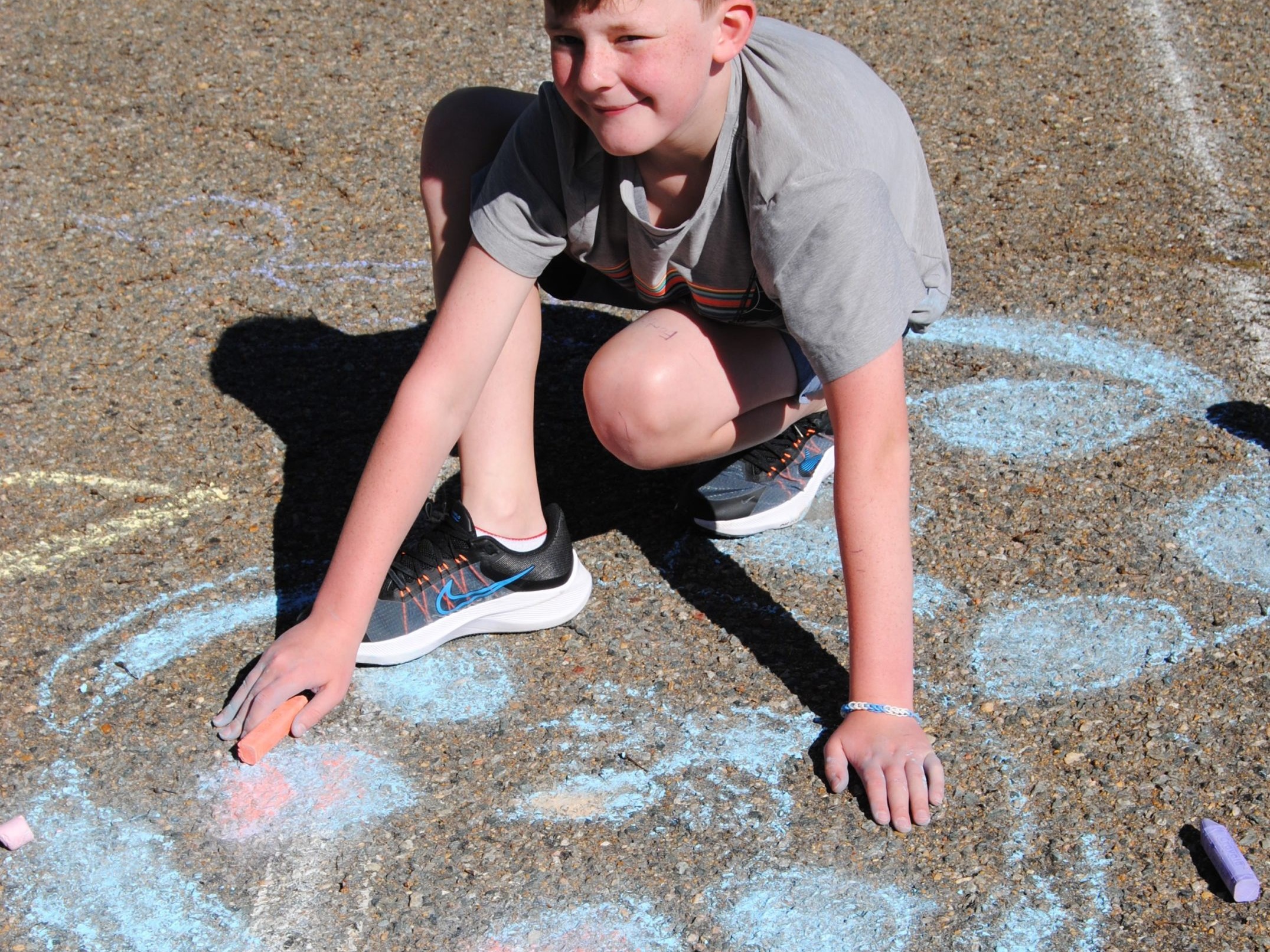 Male student showing off chalk artwork