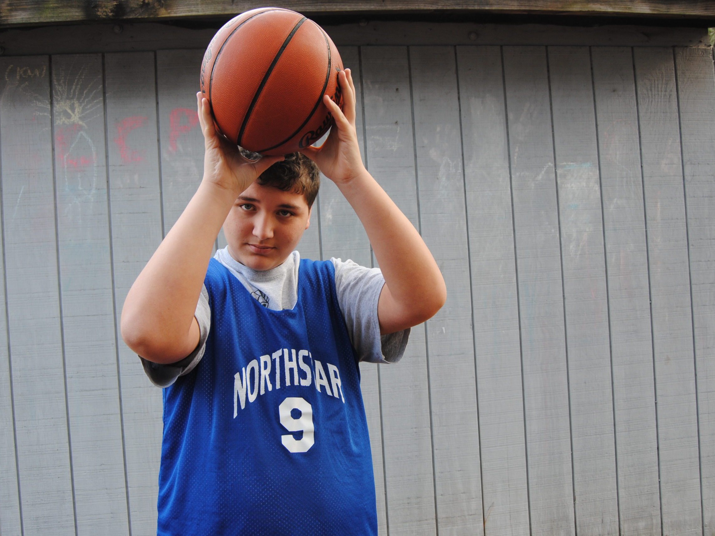 student holding basketball wearing Northstar jersey