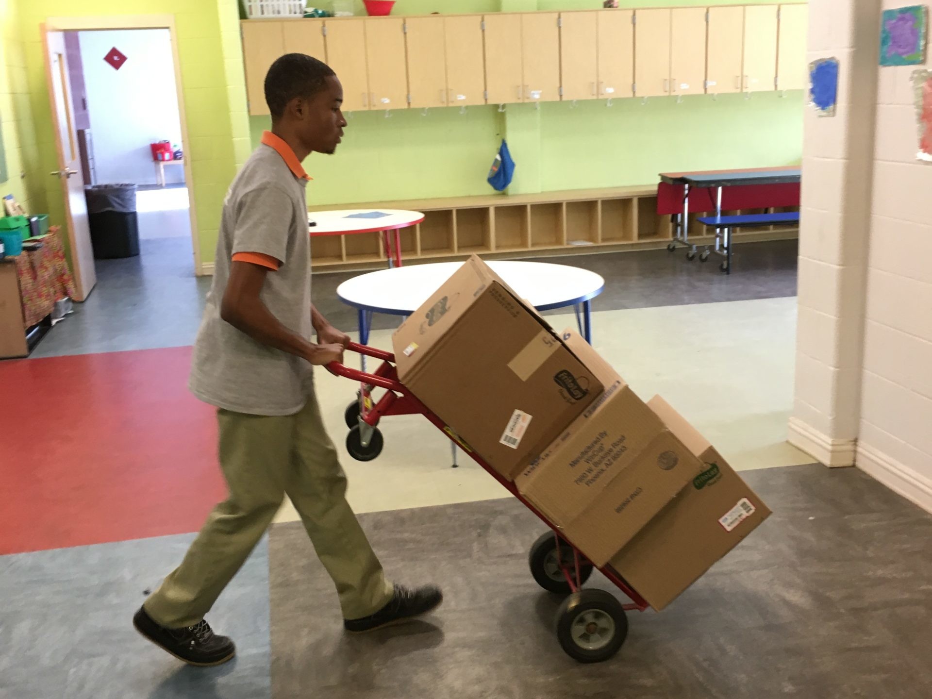 Student using dolly to transport boxes