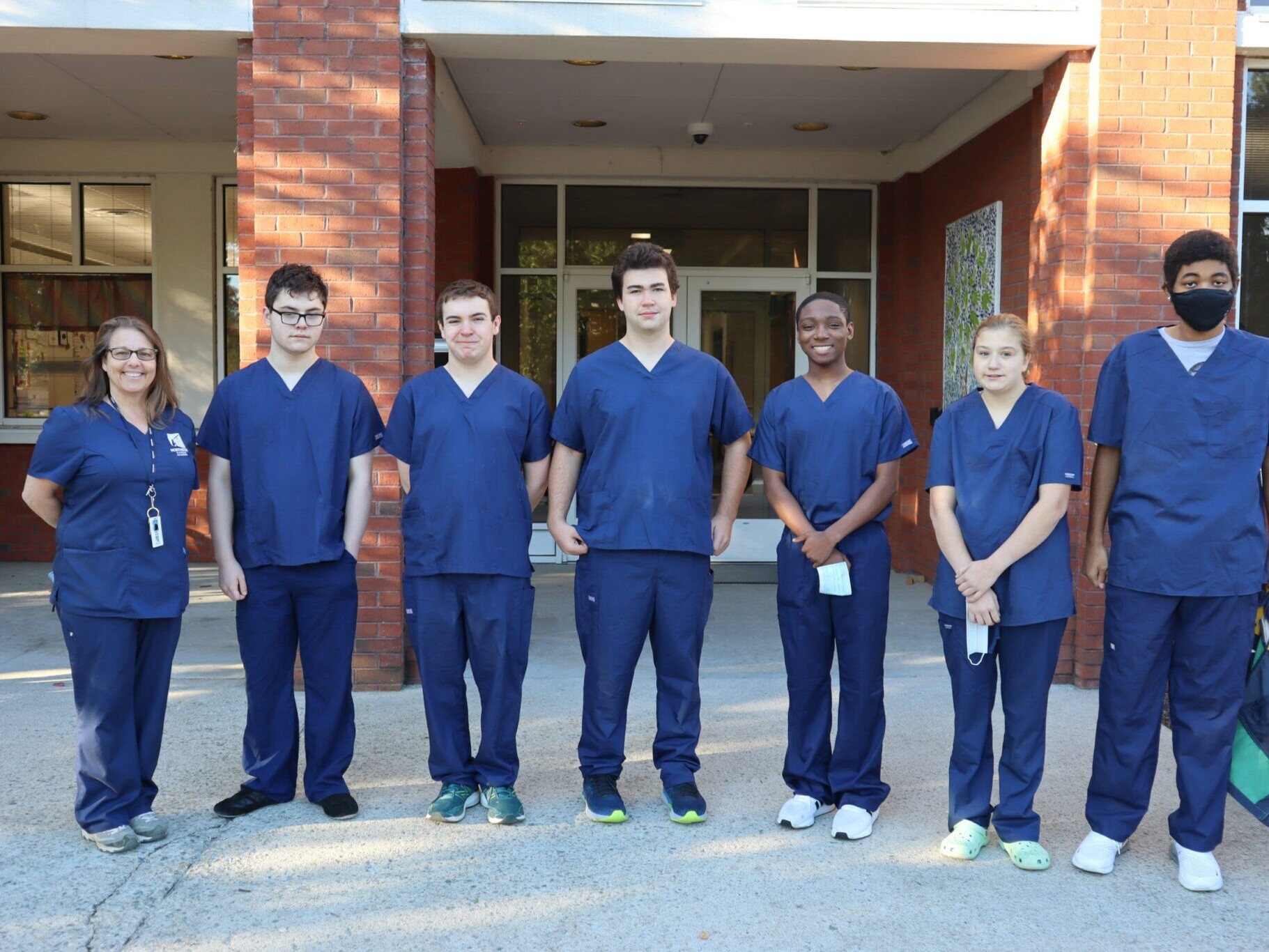 Vet assisting class outside school building smiling