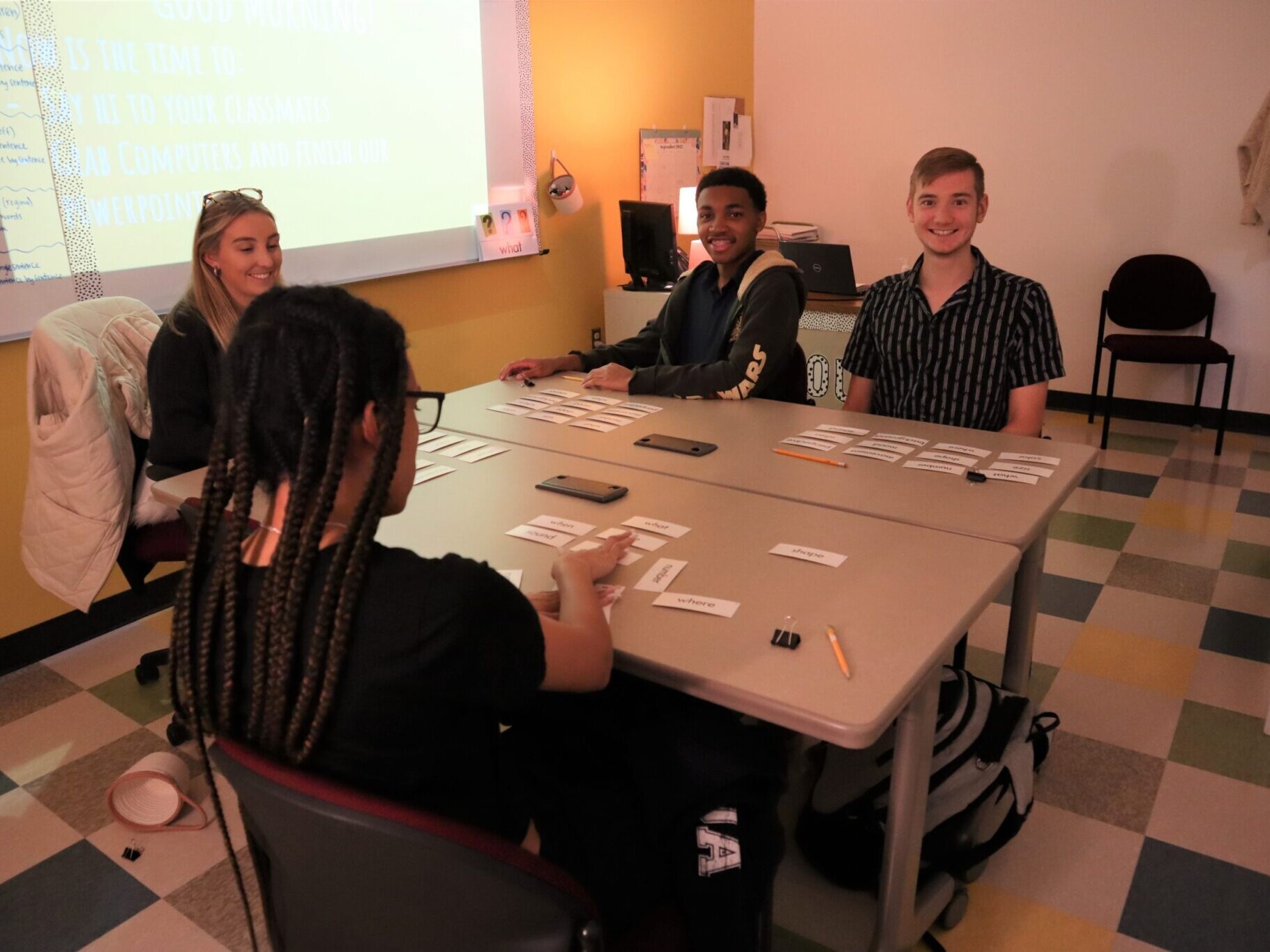 Students and teacher in classroom playing a game with word cards