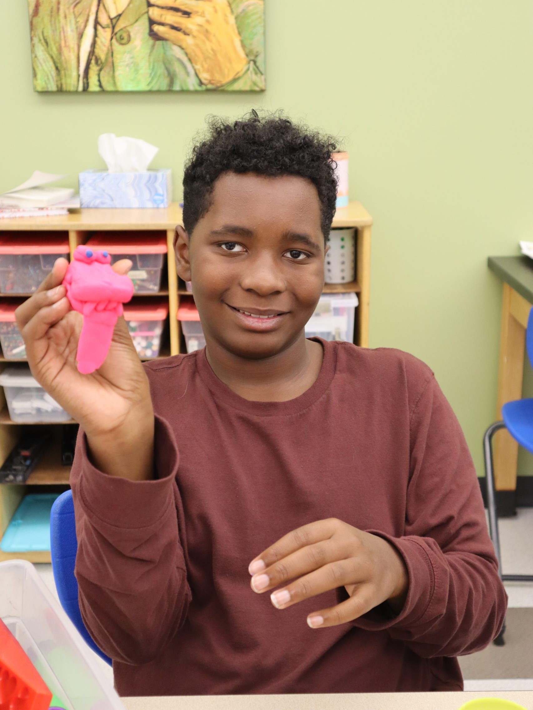 Student holding alligator mascot created out of playdoh