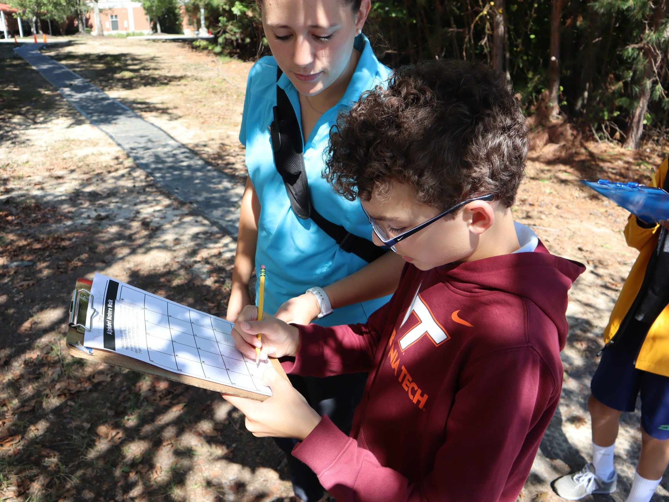 Student and teacher participating in an outdoor scavenger hunt