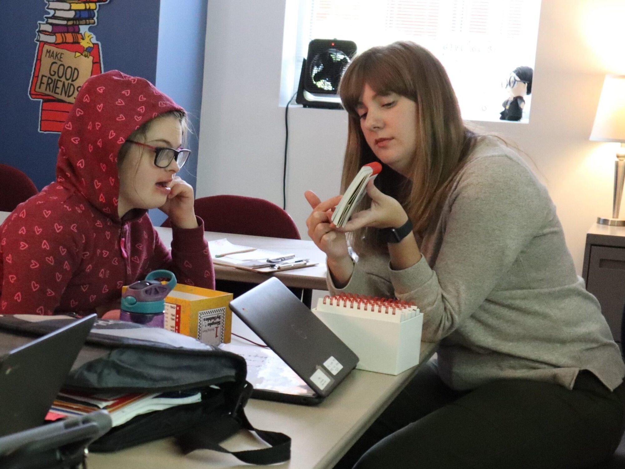 Woman pointing to card. Female student looking at card.