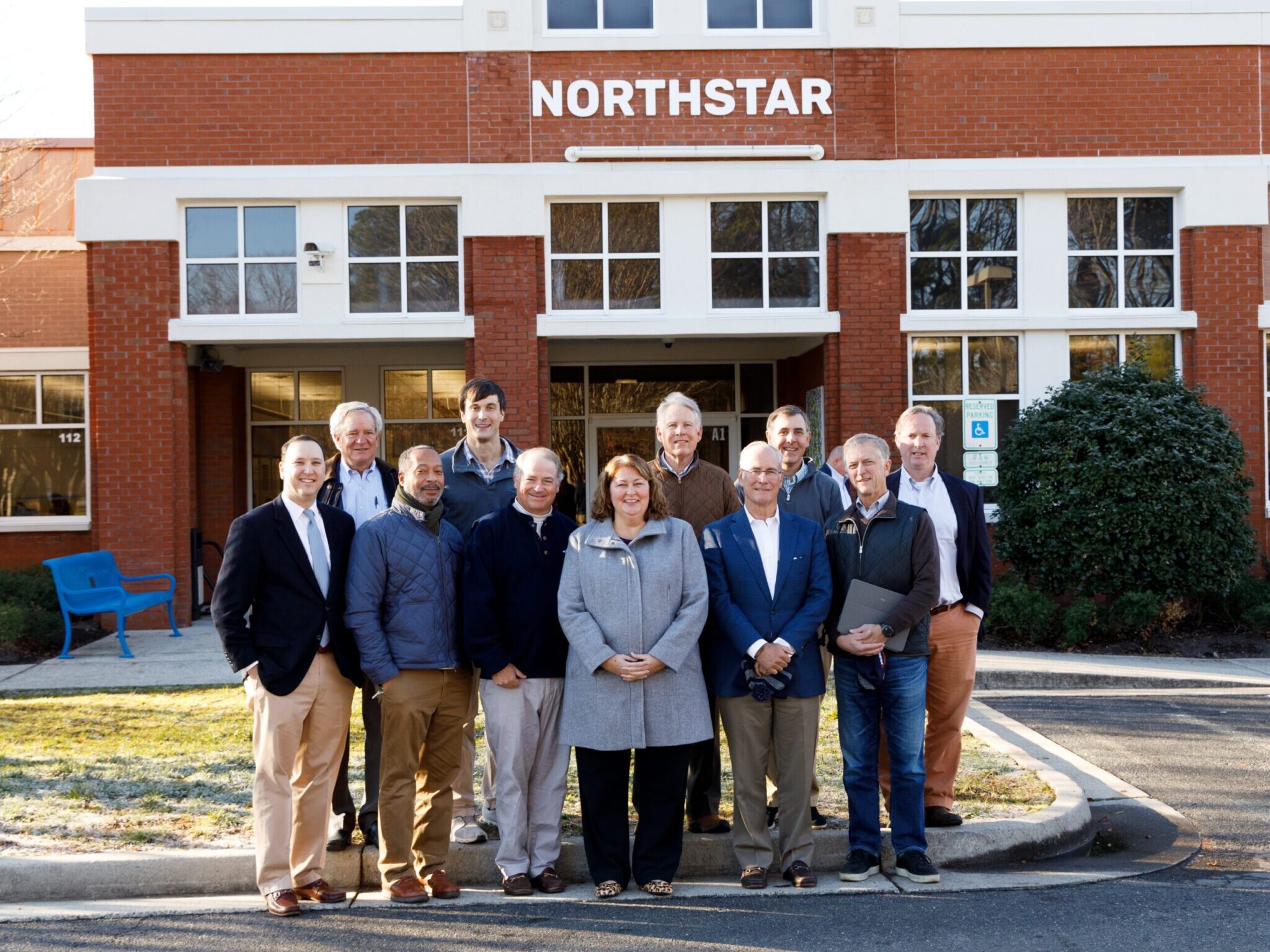 IMG 5ten male board meembers standing in front of Northstar school building with female head of school in center of group529