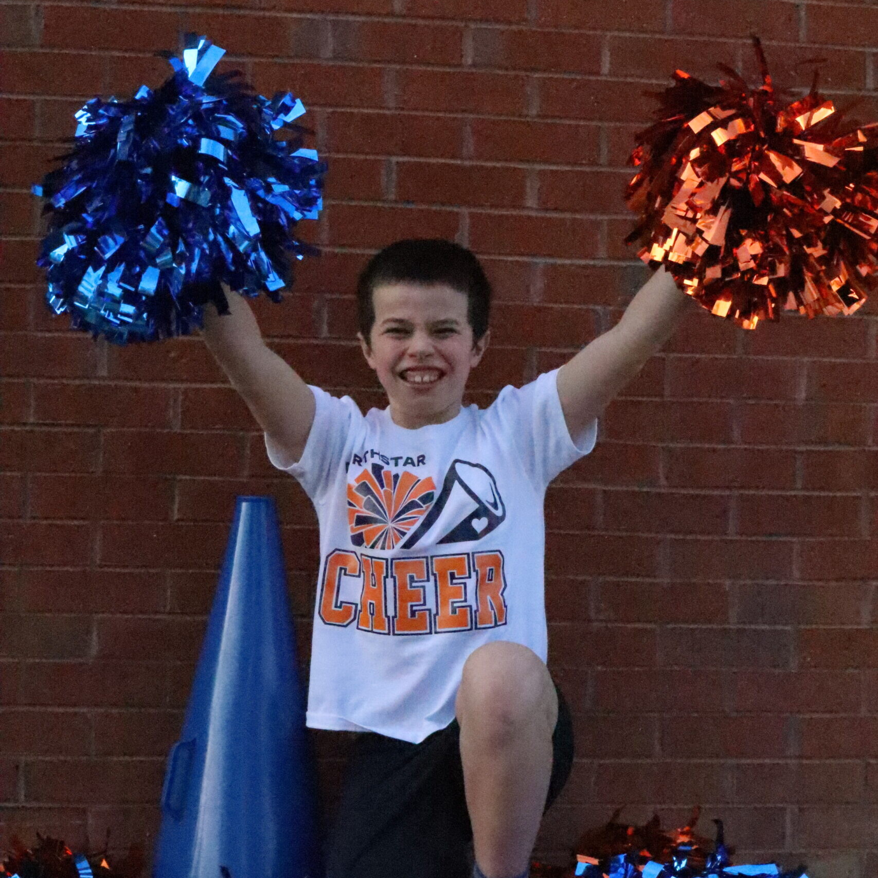 A Cheer Club member holds a pair of pompoms.
