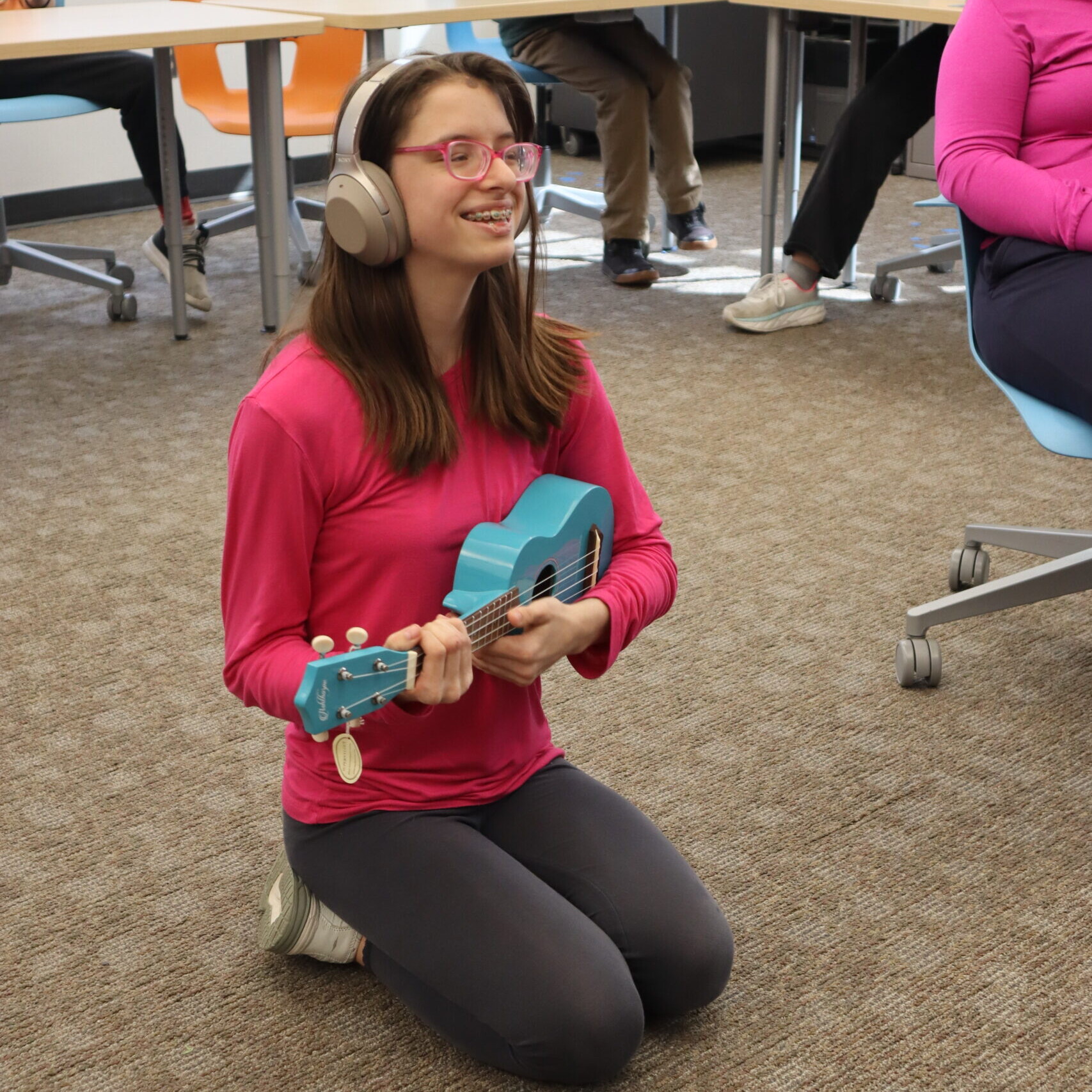 A Music Club student plays the ukulele.