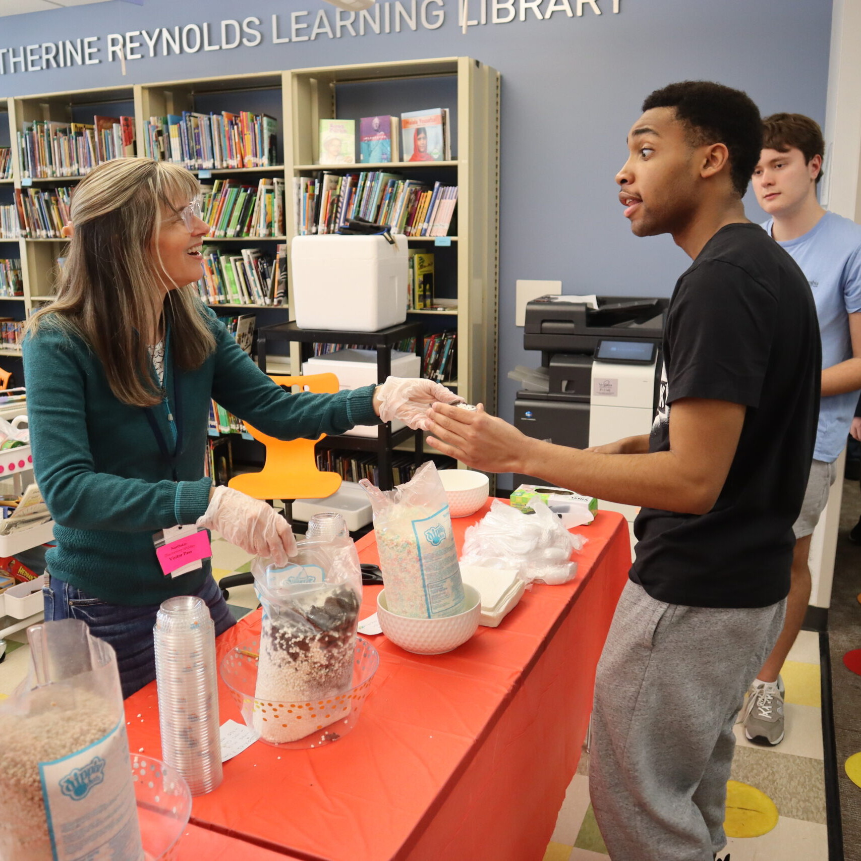 Volunteers serve ice cream during a behavior reward event.