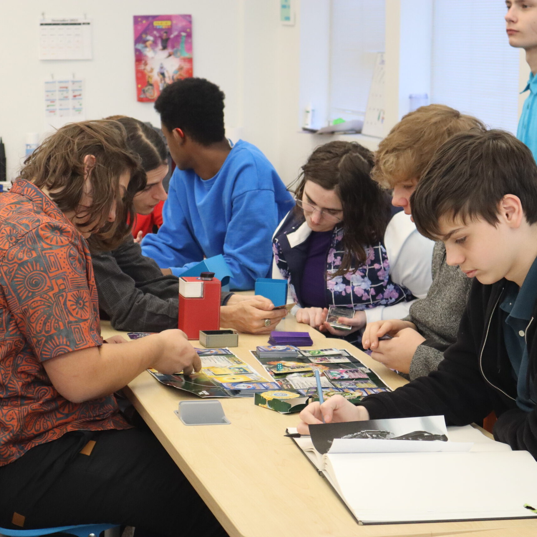 Fantasy Games Club members look at Magic the Gathering cards together.