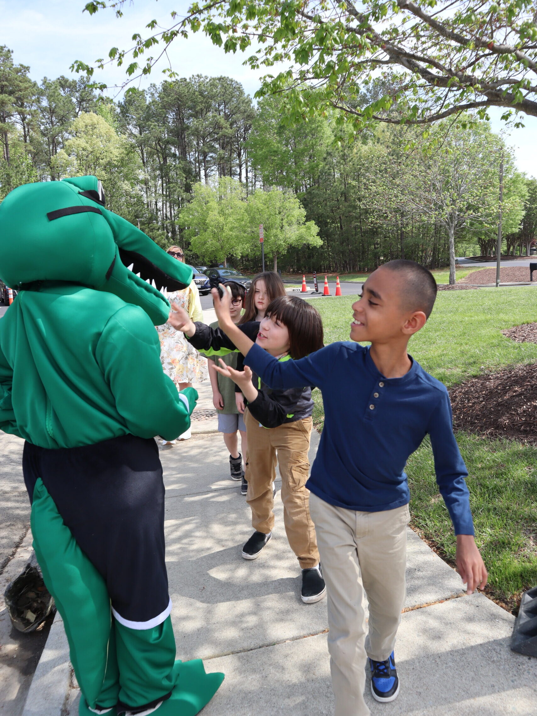 Lower Schoolers wave to Northstar mascot Navi the Gator.