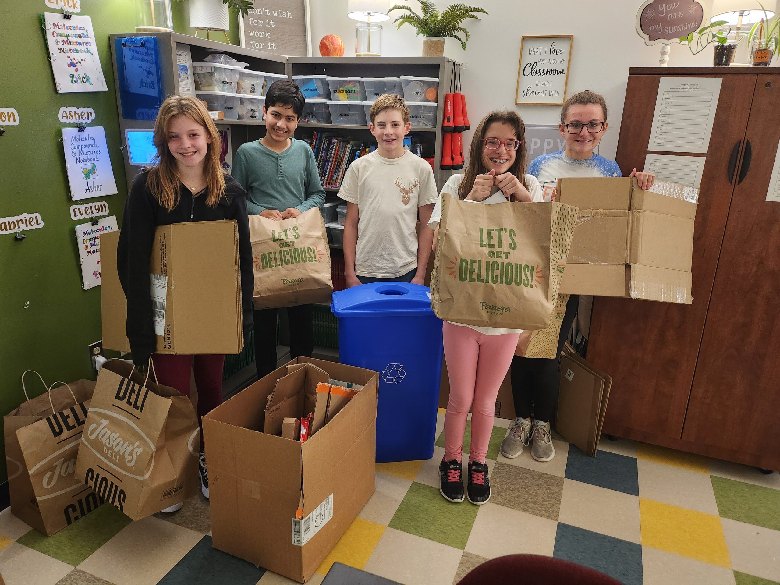 Students pose with recyclable materials they have collected and sorted from across campus.