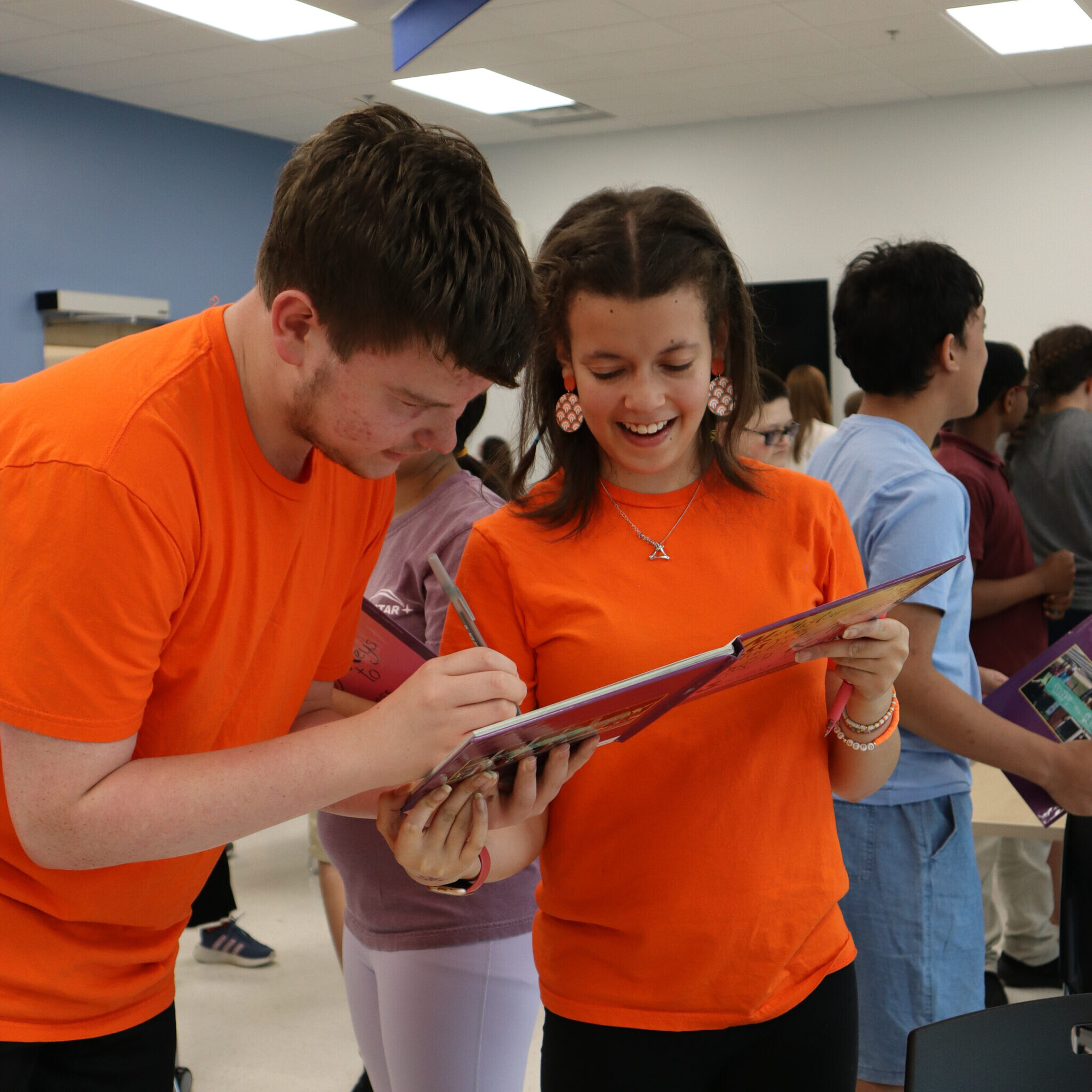 A student signs their peer's yearbook.