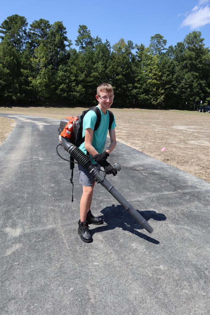 Student with leaf blower A student uses a backpack leaf blower to clear a running track.