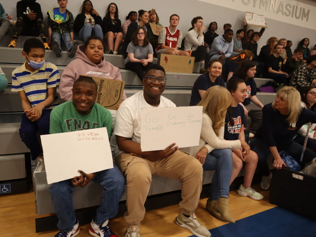 Basketball Game Audience Students wave handmade signs to cheer on the players from the bleachers.